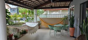 a porch with hammocks and a table and chairs at Condomínio Sol Marina in Camaçari