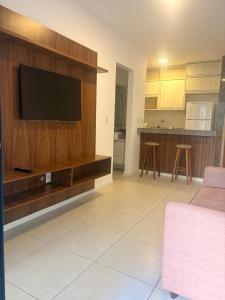 a living room with a flat screen tv on a wooden wall at Condomínio Sol Marina in Camaçari +10 photos
