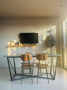 a table with two chairs and a television on a wall at Residenza Rosso Di Sera in Capoliveri