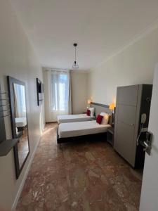 a large room with two beds and a mirror at Chambre meublée in Nice