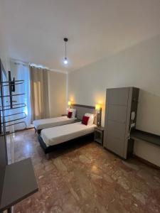 a hotel room with two beds and a table at Chambre meublée in Nice