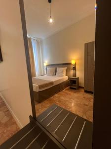 a small bedroom with a bed and a mirror at Chambre meublée in Nice