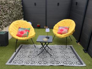 two yellow chairs and a table on the grass at Maison love rooms in Tours +10 photos