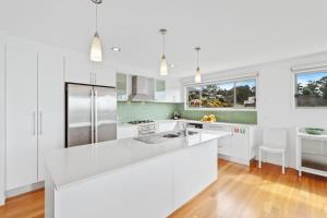 a white kitchen with a large white counter top at Three Sisters at Long Beach in Long Beach