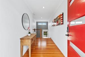 a hallway with a red door and a mirror at Three Sisters at Long Beach in Long Beach +21 photos