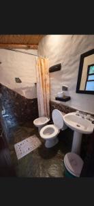 a bathroom with two toilets and a sink at Cabañas el cardon in Maimará