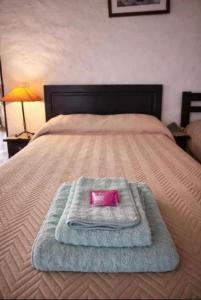 a bed with a pink tray on top of it at Cabañas el cardon in Maimará