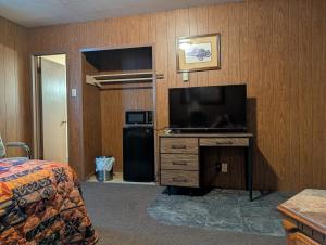 a hotel room with a television and a bedroom at Lang's Motel in Wabigoon