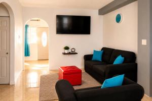 a living room with a couch and a red stool at The Hideaway Suite, largest master, ocean glimpse in Florence Hall