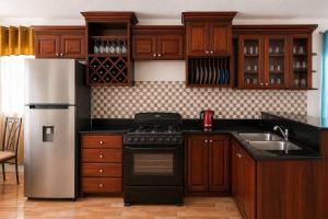 a kitchen with wooden cabinets and a stove and a sink at The Hideaway Suite, largest master, ocean glimpse in Florence Hall