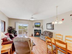 a living room with a couch a table and a fireplace at Whispering Pines 111 Lazy Bear in Pigeon Forge