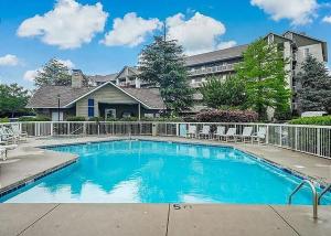 a large blue swimming pool in front of a house at Whispering Pines 111 Lazy Bear in Pigeon Forge