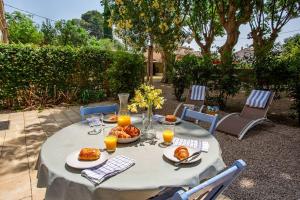 a table with plates of food and glasses of orange juice at 5 Family Apartments with Pool & Large Garden in Historic Pézenas Convent in Pézenas