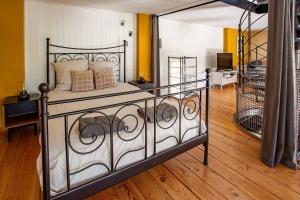 a bedroom with a bed with a wrought iron railing at 5 Family Apartments with Pool & Large Garden in Historic Pézenas Convent in Pézenas +25 photos