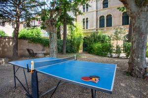 a blue ping pong table in front of a building at 5 Family Apartments with Pool & Large Garden in Historic Pézenas Convent in Pézenas