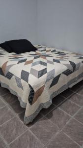 a bed with a checkered blanket on the floor at Portobelo in San Juan