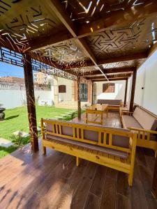 a porch with benches and a table and a view of a field at El-Rabee Hotel in Al Aqālitah