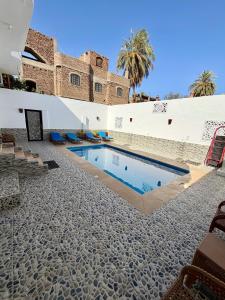 a swimming pool in the courtyard of a building at El-Rabee Hotel in Al Aqālitah