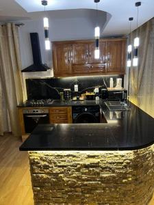 a kitchen with a black counter top and wooden cabinets at مفروشة السعادة in Tlemcen