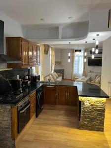 a kitchen with wooden cabinets and a black counter top at مفروشة السعادة in Tlemcen