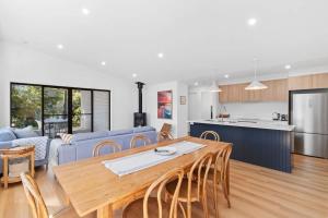 a kitchen and a living room with a table and chairs at Tranquil at Rosedale in Tomakin