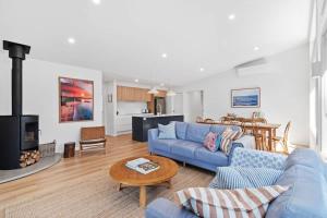 a living room with a blue couch and a fireplace at Tranquil at Rosedale in Tomakin