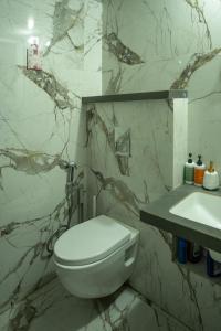 a bathroom with a white toilet and a sink at Casa Lucia in Pune +18 photos