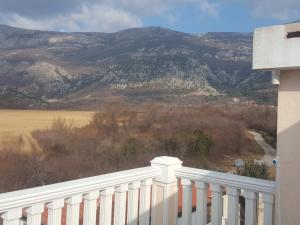 a white fence with a view of a mountain at Buljarica Bay Apartments in Petrovac na Moru
