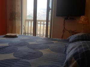 a bedroom with a bed with a large window at Buljarica Bay Apartments in Petrovac na Moru