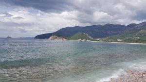 a large body of water with mountains in the background at Buljarica Bay Apartments in Petrovac na Moru