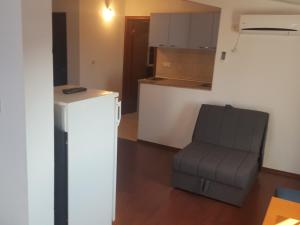 a living room with a chair and a kitchen at Buljarica Bay Apartments in Petrovac na Moru