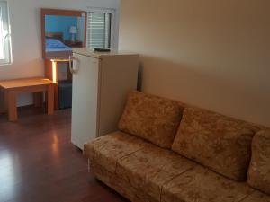 a living room with a couch and a refrigerator at Buljarica Bay Apartments in Petrovac na Moru