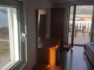 a room with a refrigerator and a window with a balcony at Buljarica Bay Apartments in Petrovac na Moru