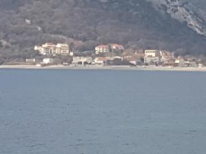 a large body of water with houses in the background at Buljarica Bay Apartments in Petrovac na Moru
