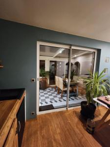 a kitchen with a sliding glass door with a living room at Les ridens in Sangatte