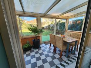 a conservatory with a table and chairs on a checkered floor at Les ridens in Sangatte