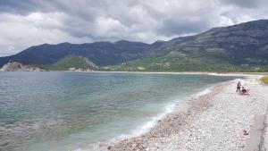 a group of people standing on a beach near the water at Buljarica Bay Apartments in Petrovac na Moru