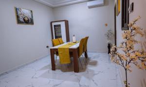 a dining room table with yellow chairs and a mirror at The Rehoboth in Sakumona