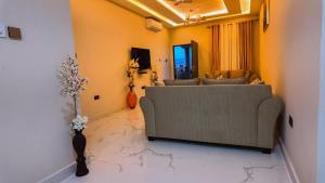 a living room with a couch and a vase with flowers at The Rehoboth in Sakumona