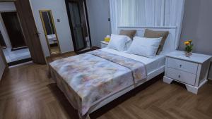 a bedroom with a large bed and a night stand at The Rehoboth in Sakumona