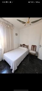 a bedroom with a white bed and a ceiling fan at Leydi 2 in Alicante