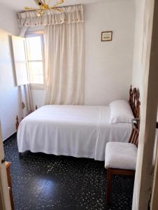 a bedroom with a white bed and a window at Leydi 2 in Alicante