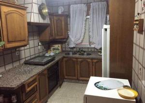 a small kitchen with wooden cabinets and a sink at Leydi 2 in Alicante