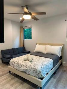 a bedroom with a bed and a ceiling fan at 1 full bed with En-Suite bath surrounded by greenery in Austin