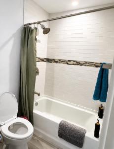 a bathroom with a white tub and a toilet at 1 full bed with En-Suite bath surrounded by greenery in Austin