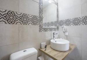 a white bathroom with a sink and a toilet at Akteon Rooms in Agia Galini +92 photos