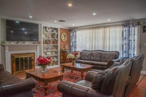 a living room with leather furniture and a television at National Harbor Guesthouse in Fort Washington