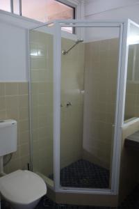 a shower with a glass door in a bathroom at Hilltop Hotel in Goonellabah