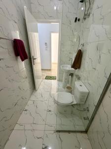 a white bathroom with a toilet and a mirror at El-Rabee Hotel in Al Aqālitah +50 photos