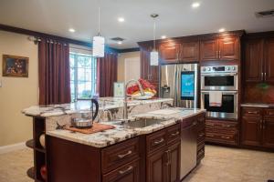 a large kitchen with wooden cabinets and a sink at National Harbor Guesthouse in Fort Washington